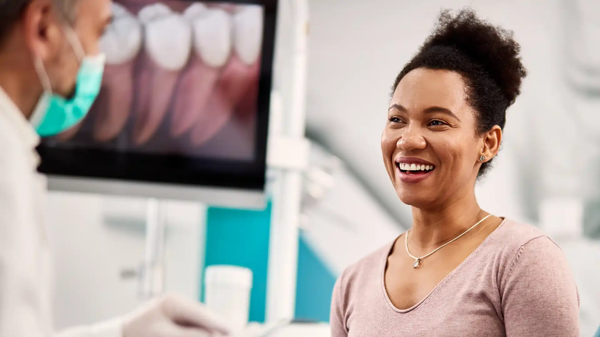 Smiling patient talking with her dentist at All Smiles General Dentistry in North Miami